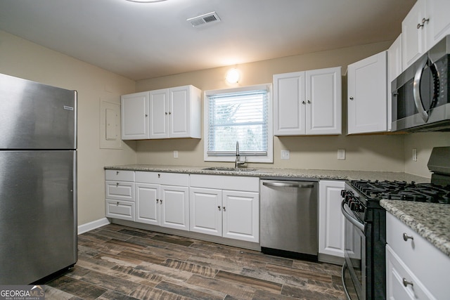 kitchen featuring appliances with stainless steel finishes, white cabinetry, and sink