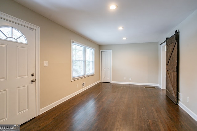 entryway featuring a wealth of natural light, dark wood-type flooring, and a barn door