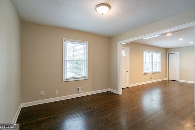 unfurnished room with dark hardwood / wood-style flooring