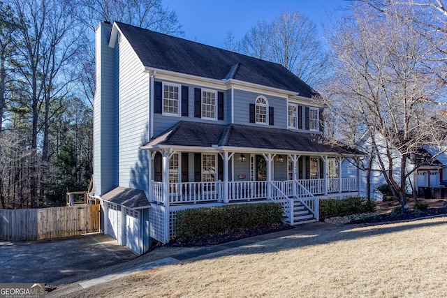 view of front of home with a front yard, a garage, and a porch