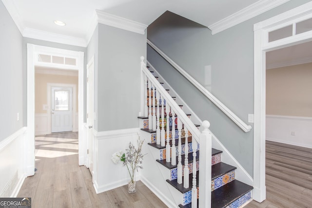 stairs featuring ornamental molding and hardwood / wood-style floors