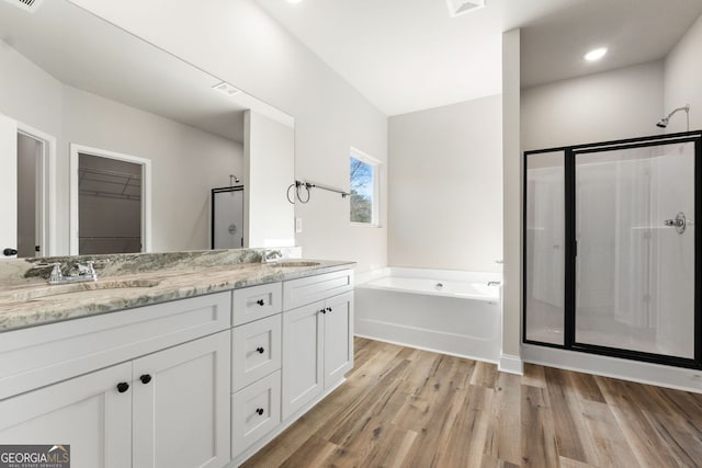 bathroom featuring hardwood / wood-style flooring, vanity, and shower with separate bathtub