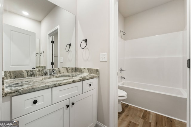 full bathroom featuring toilet, vanity, tub / shower combination, and hardwood / wood-style flooring