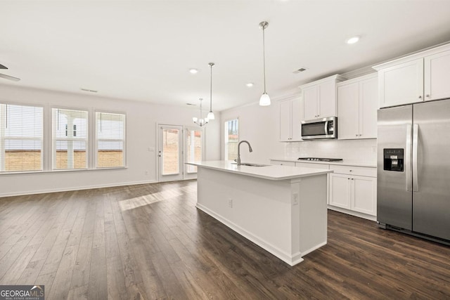 kitchen featuring sink, white cabinetry, appliances with stainless steel finishes, an island with sink, and pendant lighting