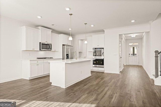 kitchen with white cabinetry, hanging light fixtures, a center island with sink, dark hardwood / wood-style floors, and stainless steel appliances