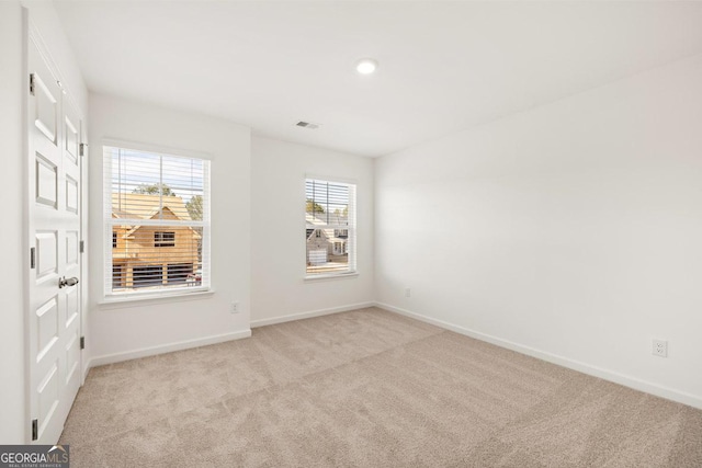 unfurnished room featuring light carpet