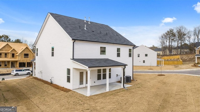 back of property featuring a lawn, a patio area, and central air condition unit