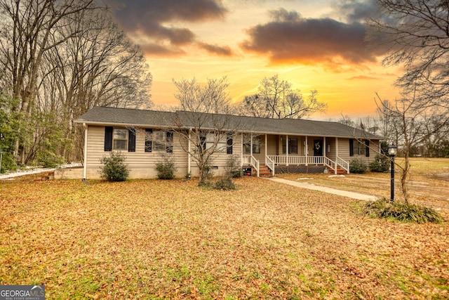 ranch-style house with covered porch and a yard