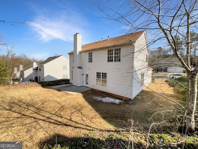 rear view of house with a patio area and a yard