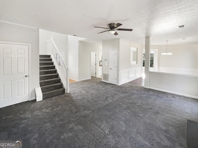 unfurnished living room with a textured ceiling, ceiling fan with notable chandelier, and dark colored carpet