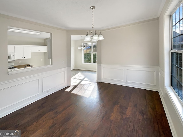 unfurnished dining area with a notable chandelier, dark wood-type flooring, and crown molding