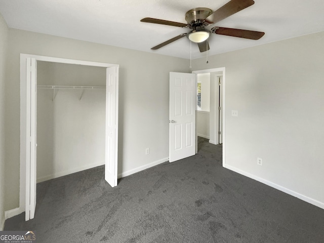 unfurnished bedroom with dark colored carpet, ceiling fan, and a closet