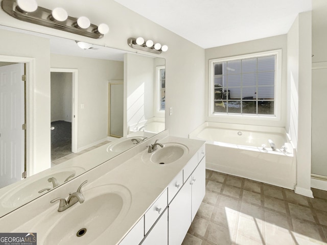 bathroom with a washtub and vanity