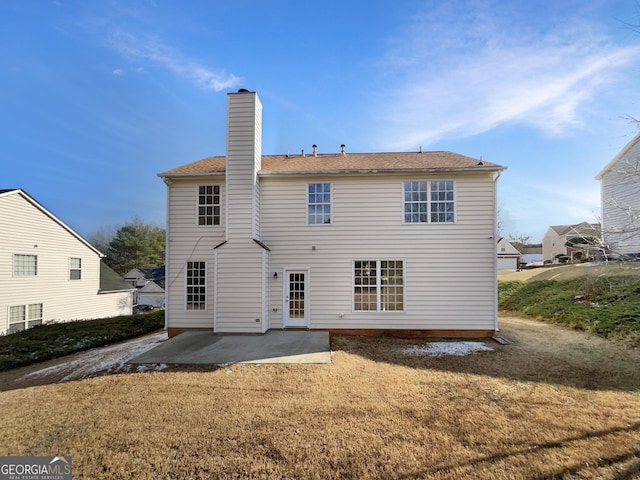 back of property with a lawn and a patio area