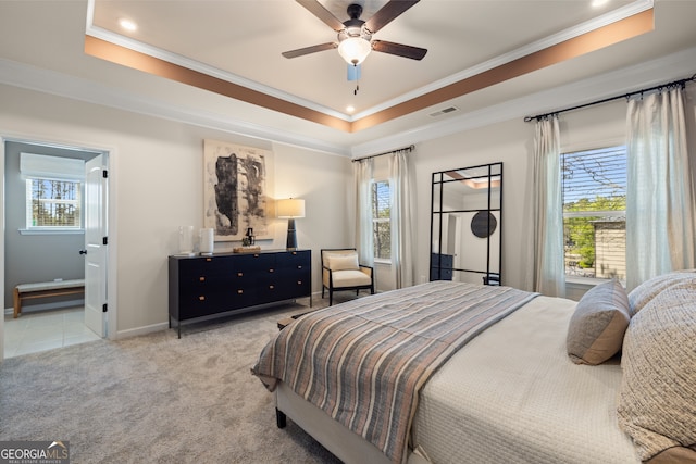 carpeted bedroom featuring ornamental molding, a raised ceiling, and ceiling fan