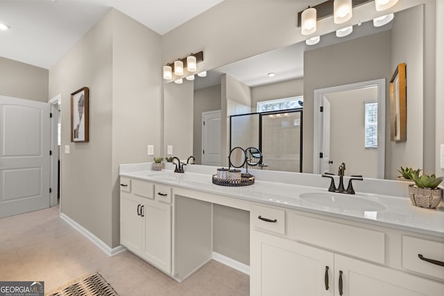 bathroom with an enclosed shower, vanity, and tile patterned flooring