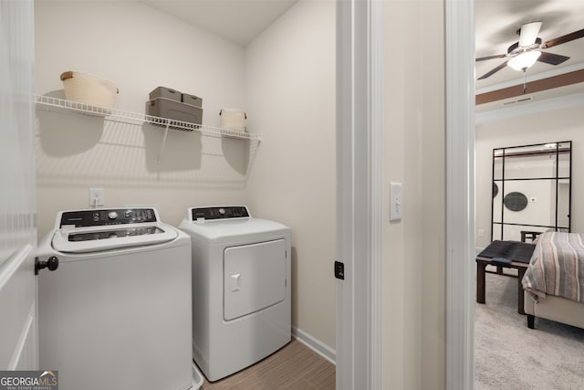 clothes washing area featuring washer and dryer, ceiling fan, ornamental molding, and light colored carpet