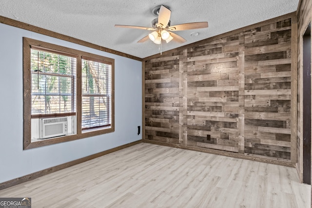 empty room with lofted ceiling, a textured ceiling, light wood-type flooring, and cooling unit