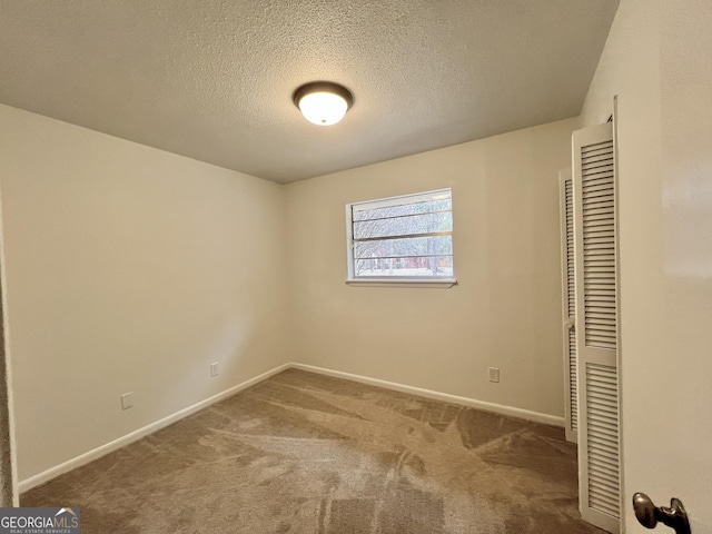 unfurnished bedroom with a textured ceiling, a closet, and carpet flooring