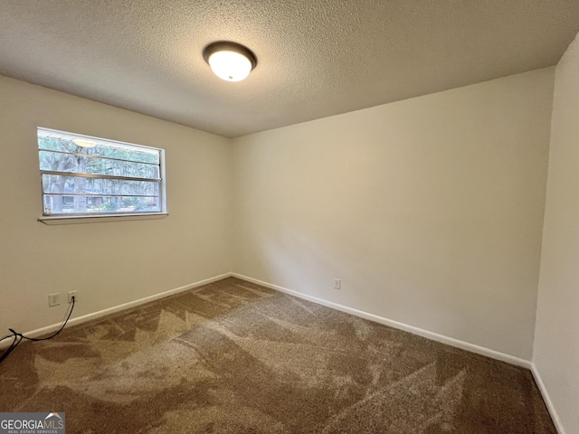 carpeted spare room featuring a textured ceiling