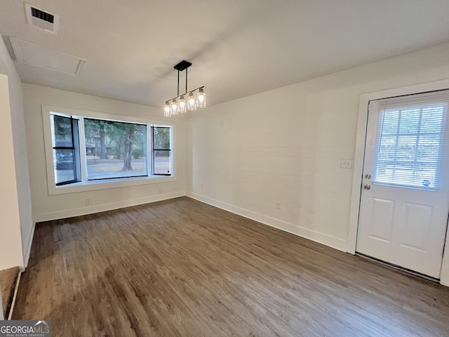 unfurnished dining area featuring dark hardwood / wood-style flooring and a chandelier