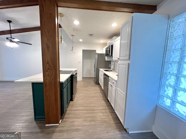 kitchen featuring stainless steel appliances, sink, white cabinets, decorative light fixtures, and beam ceiling