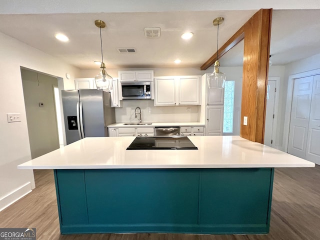 kitchen with decorative light fixtures, white cabinetry, appliances with stainless steel finishes, wood-type flooring, and sink