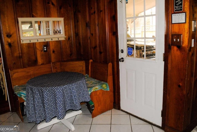 entryway with wood walls and light tile patterned floors