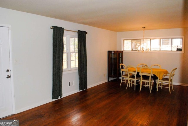 dining room featuring dark wood-type flooring and a chandelier