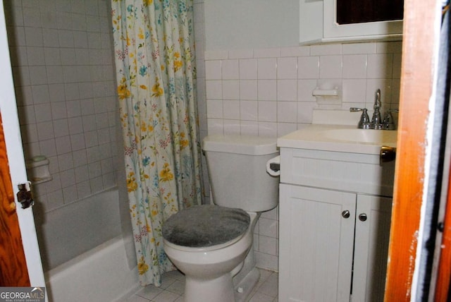 full bathroom featuring toilet, tile patterned flooring, vanity, and tile walls