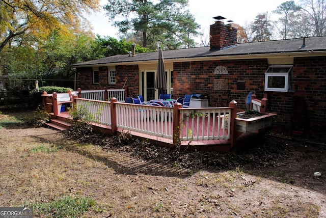 rear view of property featuring a wooden deck