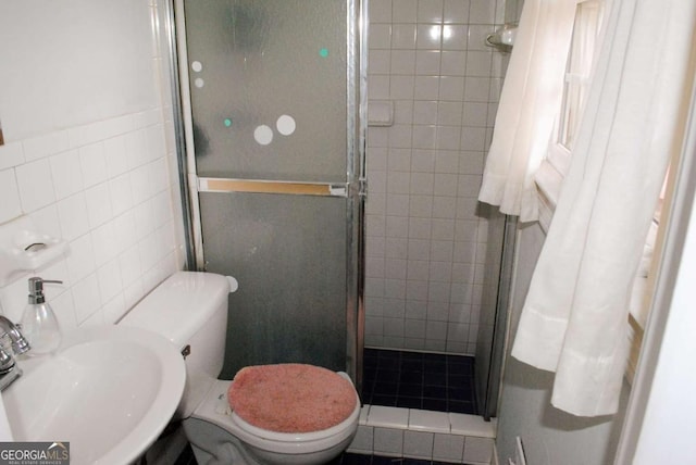 bathroom featuring toilet, tile walls, walk in shower, and sink