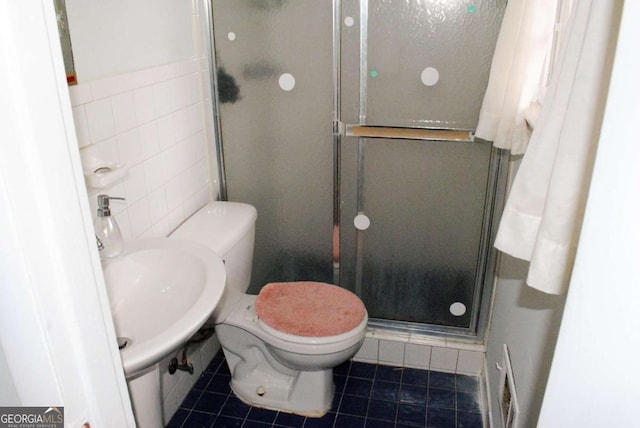 bathroom with sink, tile patterned flooring, tile walls, toilet, and a shower with door