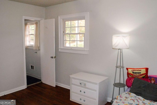 bedroom featuring multiple windows and dark hardwood / wood-style floors