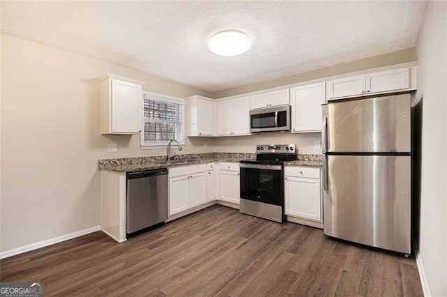 kitchen with sink, white cabinets, dark hardwood / wood-style floors, and appliances with stainless steel finishes