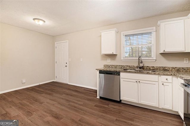 kitchen with sink, white cabinets, stainless steel dishwasher, dark stone counters, and dark wood-type flooring