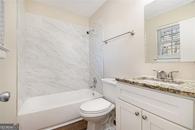 full bathroom with toilet, vanity, and tiled shower / bath