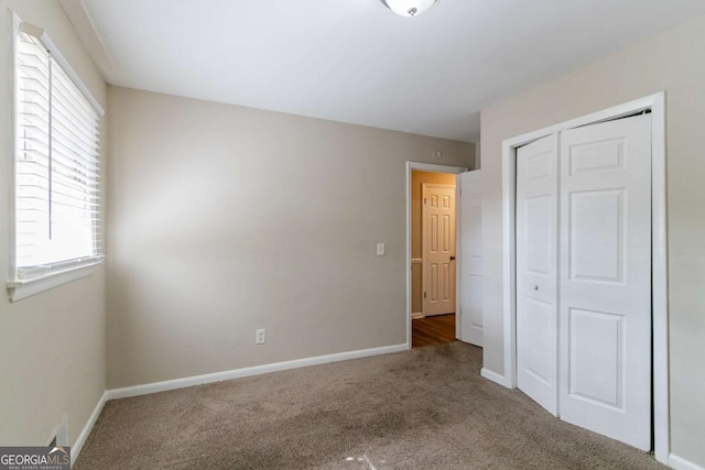 unfurnished bedroom featuring a closet and carpet flooring