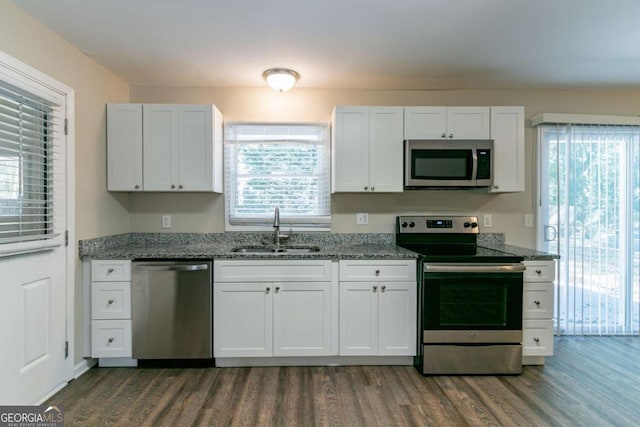 kitchen featuring sink, white cabinetry, dark stone counters, and appliances with stainless steel finishes