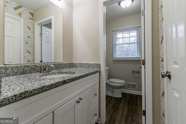 bathroom with toilet, wood-type flooring, and vanity