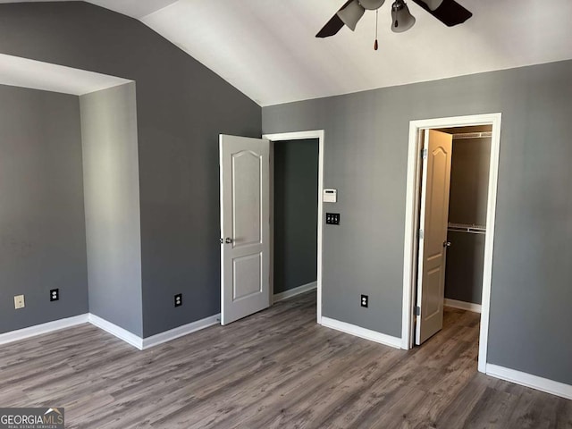 unfurnished bedroom with vaulted ceiling, hardwood / wood-style flooring, ceiling fan, and a closet