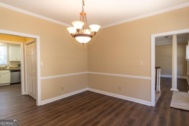 spare room featuring a chandelier, ornamental molding, and dark wood-type flooring