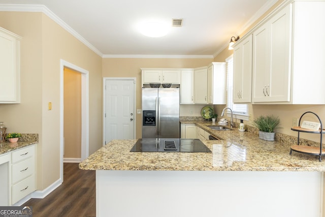 kitchen featuring kitchen peninsula, stainless steel fridge, and white cabinetry