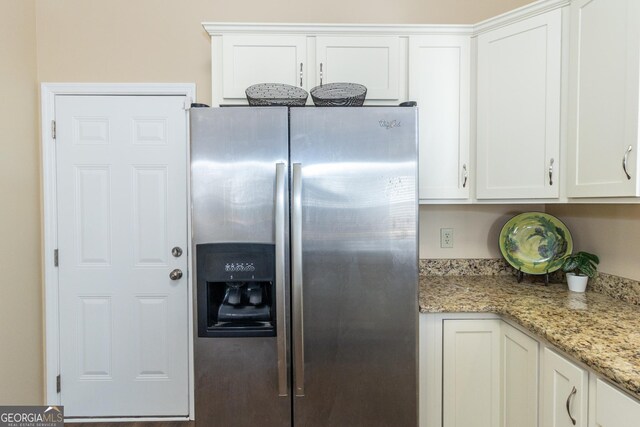 kitchen with white cabinets, light stone countertops, and stainless steel refrigerator with ice dispenser