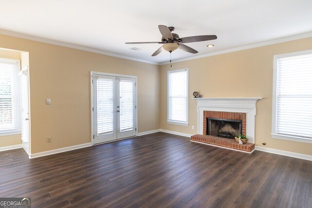 unfurnished living room featuring a fireplace, a wealth of natural light, crown molding, and dark wood-type flooring