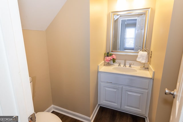 bathroom with toilet, wood-type flooring, and vanity