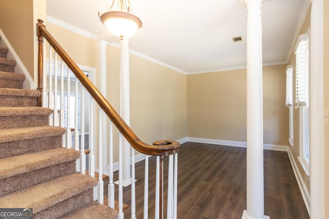 stairway with hardwood / wood-style floors, crown molding, and ornate columns