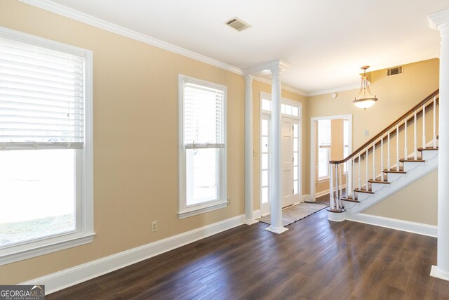 entrance foyer with decorative columns, dark wood-type flooring, crown molding, and a healthy amount of sunlight