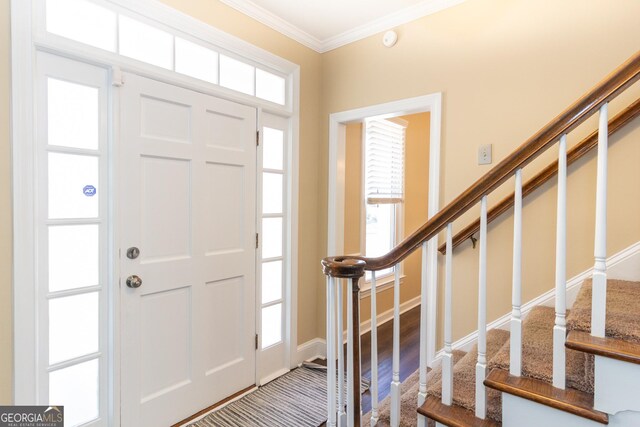 entrance foyer featuring crown molding and plenty of natural light