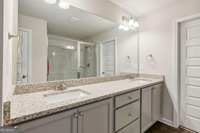 bathroom with wood-type flooring, vanity, and a shower with shower door